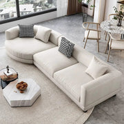 Modern living room with a beige sectional sofa, checkered pillows, and a marble coffee table.